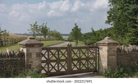 Looking down a driveway through ornate wooden gates