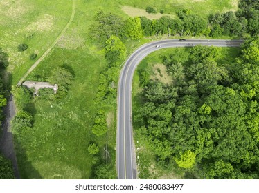 looking down at empty road from above (drone shot of highway) green trees landscape countryside driving scenic country usa north america