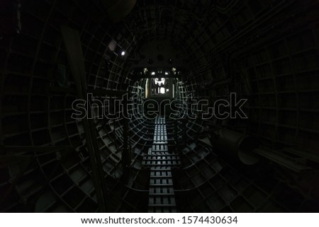 Looking down the fuselage of a vintage aircraft towards the rear gunner post at the rear tail.