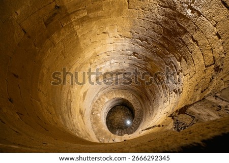 Looking down into the ancient Nilometer at the Temple of Kom Ombo, a structure used to measure the water level of the Nile River.