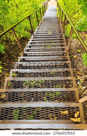 Looking down long steps of metal stairs with a railing