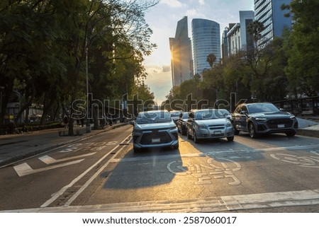 Looking down a multi-lane downtown road with oncoming cars at dusk.
