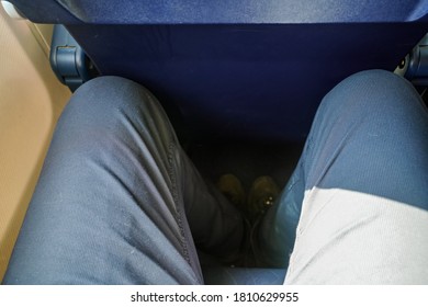 Looking Down At Narrow Leg Space In Low Cost Airline Seat, Knees Touching Back Rest At Front