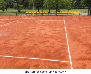 Looking down the nets across the many tennis courts wet after a rain shower 