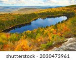 Looking down on Lake Solitude from the White Cliffs on Mt. Sunapee in Newbury, New Hampshire, with brilliant fall foliage below.