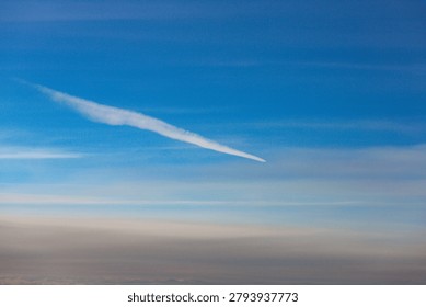 Looking down on a sea of clouds from high above, revealing layers of white fluff against the endless blue expanse of the atmosphere