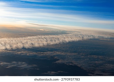 Looking down on a sea of clouds from high above, revealing layers of white fluff against the endless blue expanse of the atmosphere
