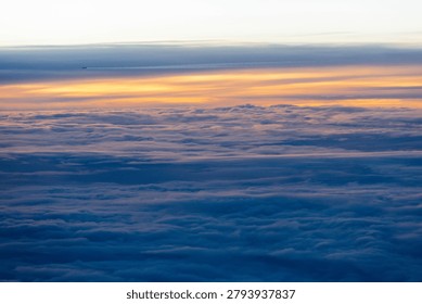Looking down on a sea of clouds from high above, revealing layers of white fluff against the endless blue expanse of the atmosphere