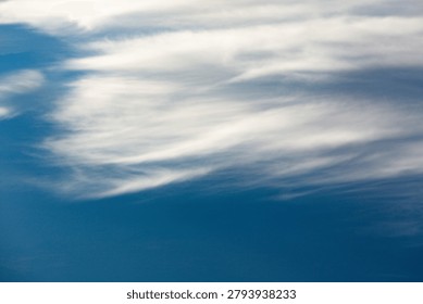 Looking down on a sea of clouds from high above, revealing layers of white fluff against the endless blue expanse of the atmosphere