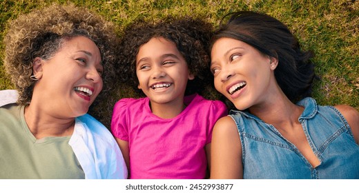 Looking Down On Three Generation Female Family Laughing And Lying On Grass Outdoors In Countryside - Powered by Shutterstock