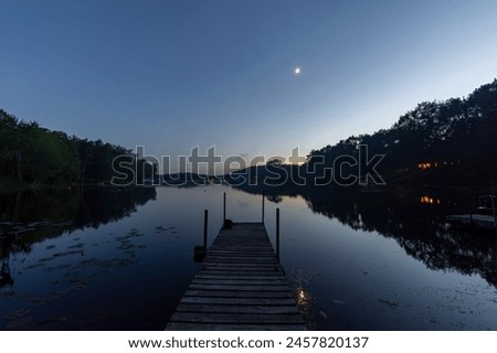 Looking down a pier on a calm Wisconsin lake after sunset.