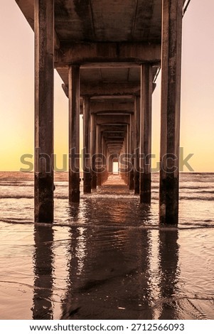 Looking down the pilings below Scripps Pier as the sunsets over the Pacific Ocean