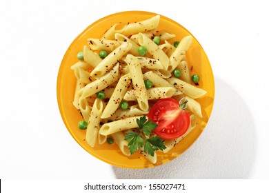 Looking Down At A Plate Of Cooked Tubular Pasta With Seasoning Herbs / Top View Of Flavored Macaroni Noodles Served With Green Parsley And Tomato In An Orange Plate - Isolated On White Background 