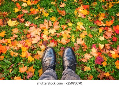 Looking Down At Shoes, Colorful Autumnal Leaves On The Ground.