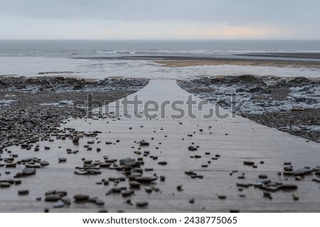 Looking down a slipway onto a beach at Ogmore-by-sea after heavy rainfall