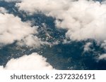 Looking down to small town from Airplane window through white clouds