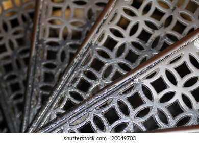 Looking Down Some Steps Of A Wrought Iron Spiral Staircase.