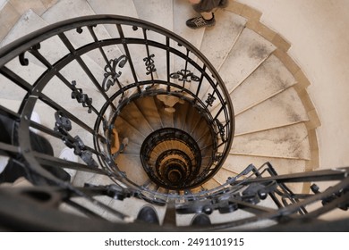 Looking down a spiraling staircase with ornate iron railings, creating a mesmerizing and dizzying visual effect. - Powered by Shutterstock