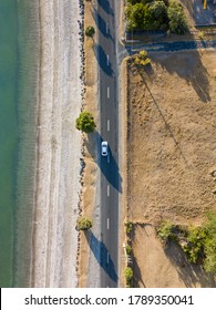 Looking Down At The Sports Car Driving Down A Coastal Road.