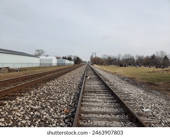 looking down a straight flat pair of railroad tracks towards the horizon, diminishing perspective, train, transportation
