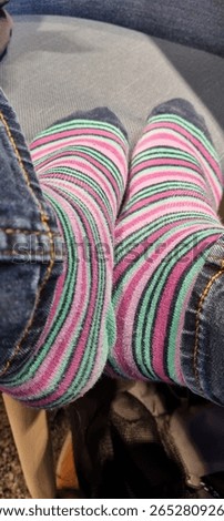 Looking down at stripey socks on feet