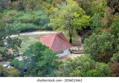 Looking down through the smudged, glass of a lookout tower in Arkansas. Trees and a building makes a nice scenic view. Bokeh.