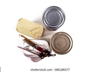 Looking Down From The Top Of A Collection Of Unlabelled Food Tins Or Cans, Some With Pull Tabs, And A Manual Can Opener Isolated On White