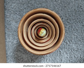 Looking down at the top of stacked Russian Nesting dolls with the top off and the inner doll peaking out. 
