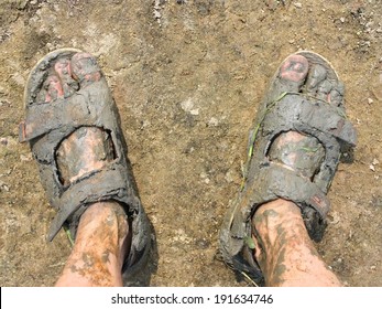 Looking Down At Two Feet In Grey Mud, From Above