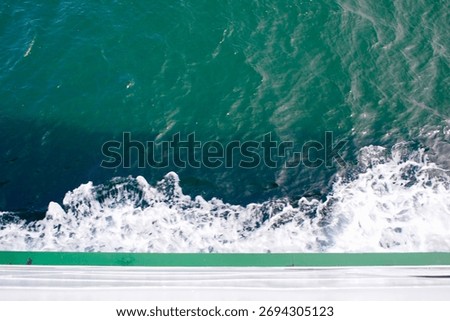 Looking down at wake waves and whitecaps from the deck of a ship       