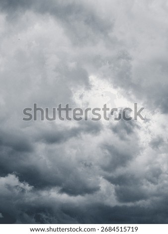 Looking up at the dramatic sky with storm clouds. Sky gradient from light grey to dark steel grey.