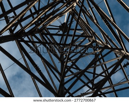 Looking up at electric pylon structure blue sky wide shot selective focus