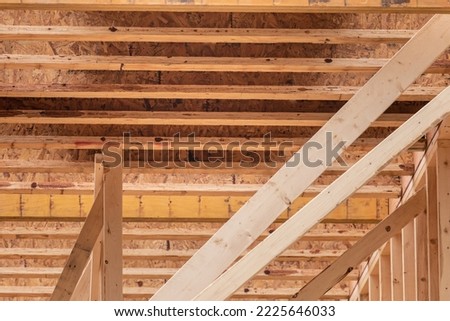 Looking up at engineered manufactured timber first floor ceiling joists in a residential construction project