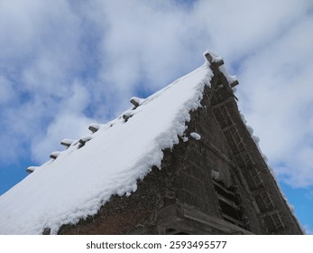 Looking up to Gassho-zukuri traditional japanese thatched roof house with big snowdrifts