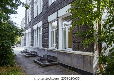 Looking up at a historic building in Irkutsk, highlighting intricate brick patterns and large windows on a clear day. - Powered by Shutterstock