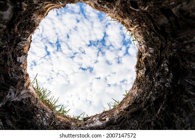 Looking up from hole in yard. Financial debt, underground utility and home construction concept.
