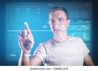 Looking impressed. Clever experienced programmer looking at the transparent screen while developing his amazing program