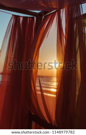 Similar – Colorful striped, closed parasol in close-up on the beach at sunset