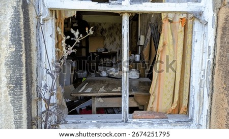 Looking into old window frame, broken missing glass. Stalker staring inside eerie abandoned home. Messy interior room. Vandalised, brick through house windows. Deserted, vanished occupants