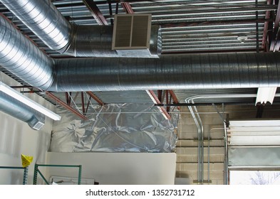 Looking Up Into The Warehouse Rafter At The Bent Vents And Garage Doors. 