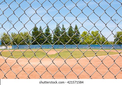 Looking at a little league baseball field through a chain link fence