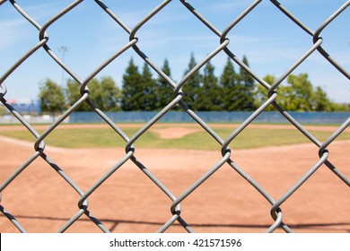 Looking At A Little League Baseball Field Through A Chain Link Fence