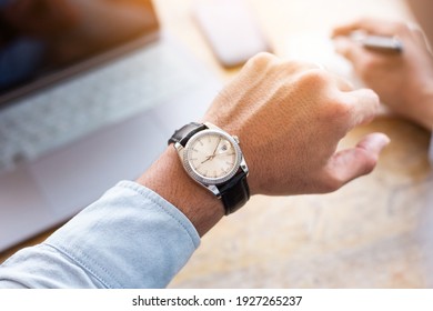 looking at luxury watch on hand check the time writing business information in notepad at workplace.concept for managing time organization working,punctuality,appointment.fashionable wearing stylish