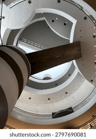 Looking up at the modern circular architecture ceiling with geometric spiral structures in bangkok, thailand