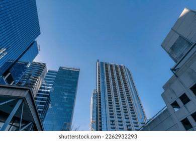 Looking up at modern residential buildings exterior towering against blue sky. Austin Texas skyline viewed from the street with facade of apartments, condominiums and offices.