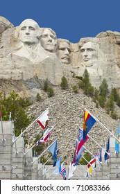Looking up at Mount Rushmore with state flags at the base