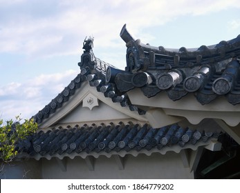Looking Up To Old Traditional Japanese House Pagoda Roof With Black Clay Roof Tile Decorated With Koi Carp Fish Sculpture On Roof Ridge