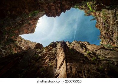Looking up on the sky surrounded by the cliffs of Towers of the Virgin in Zion Canyon National Park, Utah.