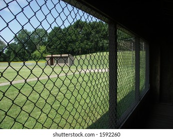 Looking out of a baseball dugout at an empty field.