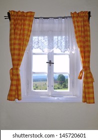 Looking out the old window with orange curtains